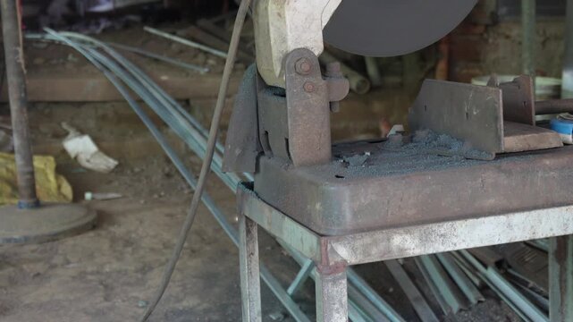 Metal worker cutting steel with angle grinder