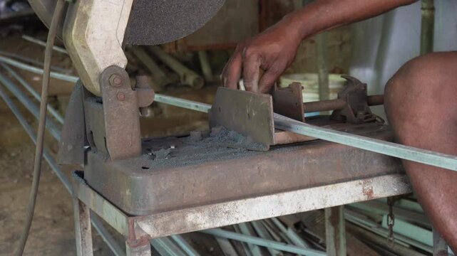 Worker measuring and cutting steel bar