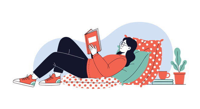Young girl wearing red sweater and glasses lying comfortably on colorful cushions reading her favorite book in cozy room.