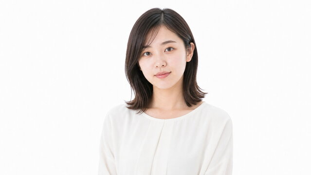 白背景のはにかんだ笑顔の若い成人日本人女性ポートレート