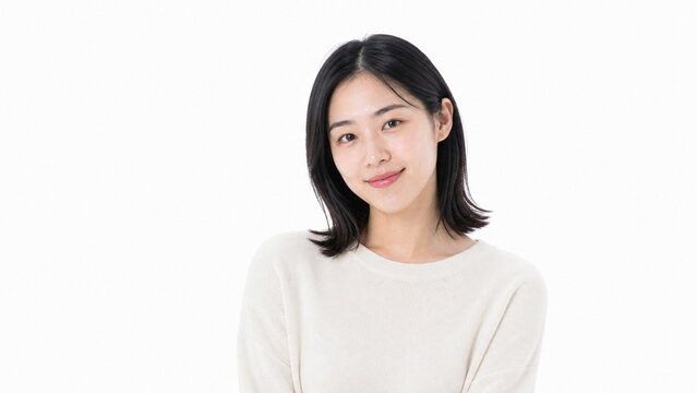 白背景の自然な微笑みの若い成人日本人女性ポートレート