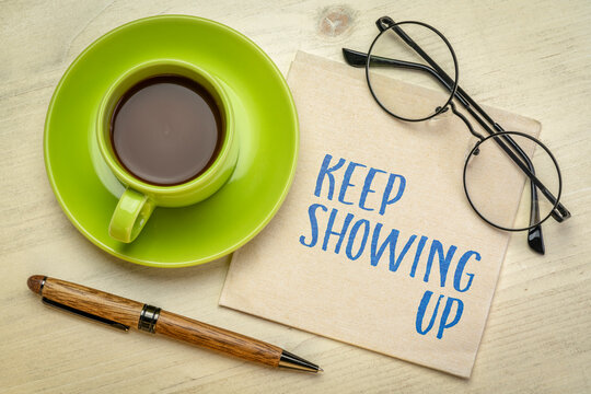 Keep Showing Up - inspirational handwritten note on a napkin with coffee and pen, encouraging consistency, resilience, discipline, and long-term success.
