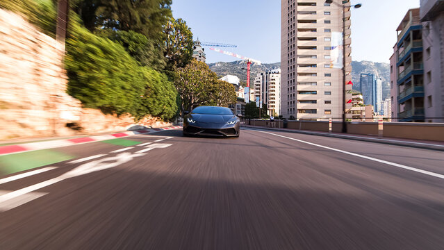 Dark grey supercar speeding on monaco street circuit