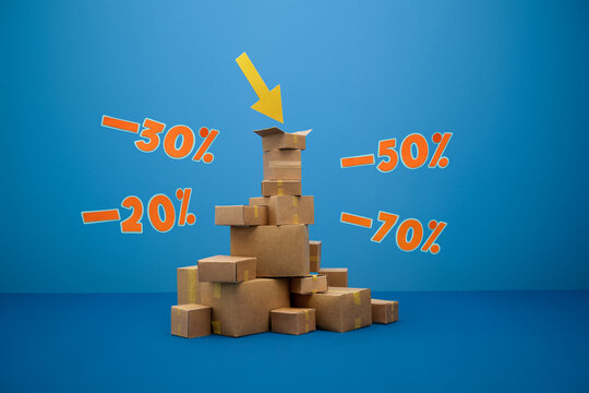 Pile of cardboard boxes with discount percentages and a downward arrow