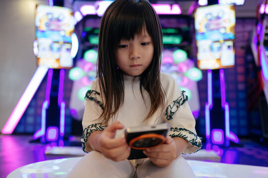 cute Asian little kid using cell phone