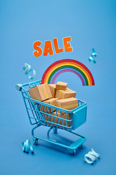 Blue shopping cart filled with cardboard boxes and a rainbow