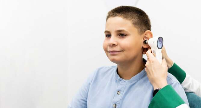 A child undergoing a hearing test with a digital otoscope at a medical center. Concept of hearing problem prevention in young children. Copy space for hearing advertising.