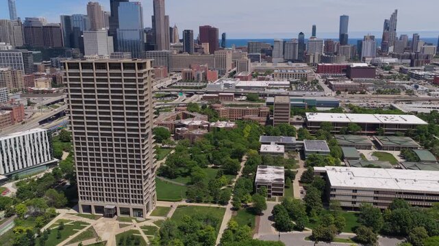 Urban panorama showing University of Illinois Chicago campus with downtown skyscrapers and Lake Michigan in background during daytime, city architecture and landscape