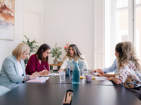 Group Discusses Ideas in a Bright Office at Daytime