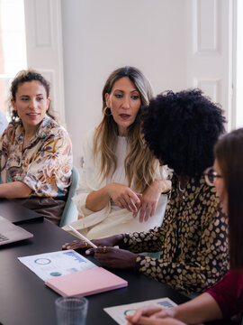 Women Engage in Discussion During a Meeting at a Bright Office