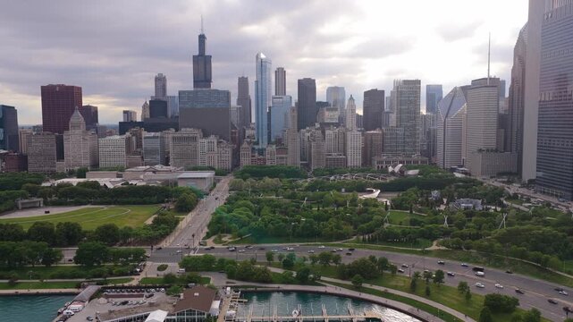Chicago skyline showing Willis Tower and Maggie Daley Park with cars driving on Lake Shore Drive, urban architecture and landscape of Illinois from above