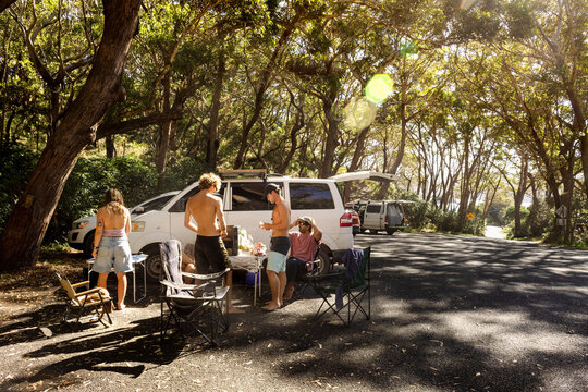 UGC friends cooking beside campervans in national park parking area
