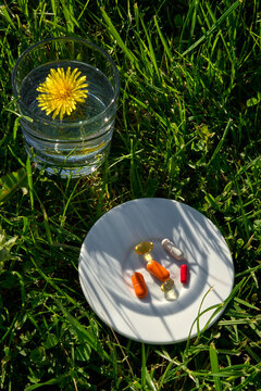 Natural Supplements and Vitamins with Water in Green Grass