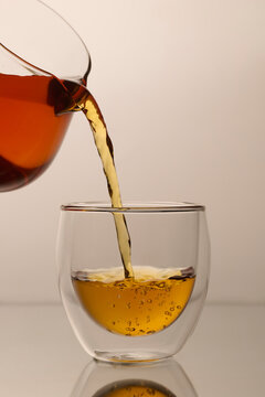 &Atilde;&sect;Amber liquid is being poured from a glass pitcher into a clear cup