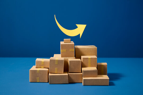 Cardboard boxes stacked in a pyramid shape with a yellow narrow