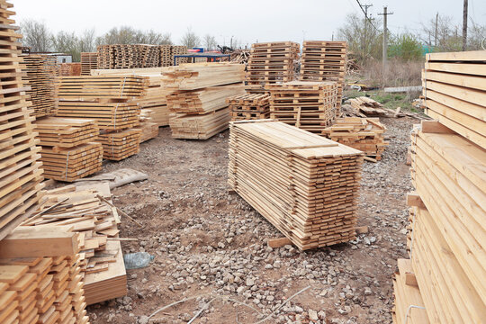Lumber warehouse. An open-air wood processing workshop. Woodworking. Manufacture of pallets made of wood for cargo transportation. Natural wood