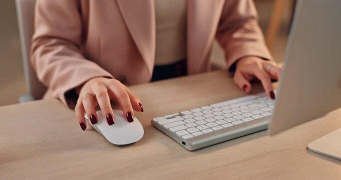 Professional Woman Typing on Keyboard and Using Mouse at Desk in Office