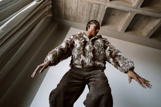 Dancer Moves in Furry Coat Indoors Under Natural Light
