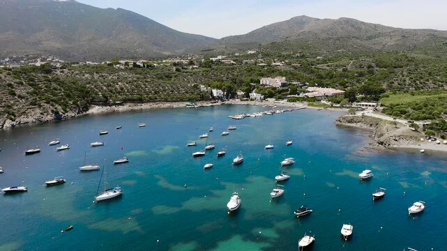 Aerial view of the peaceful Port Lligat Bay, home to Salvador Dal&iacute;'s House Museum, surrounded by crystal-clear Mediterranean waters, rocky shores and the unique landscapes of the Costa Brava. 
