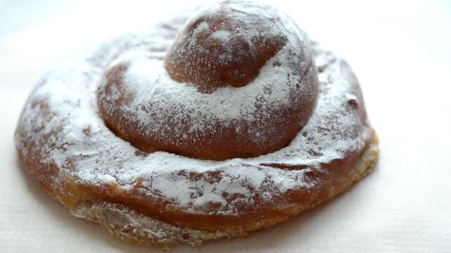 Rotating traditional ensaimada pastry on white background, top view, loopable