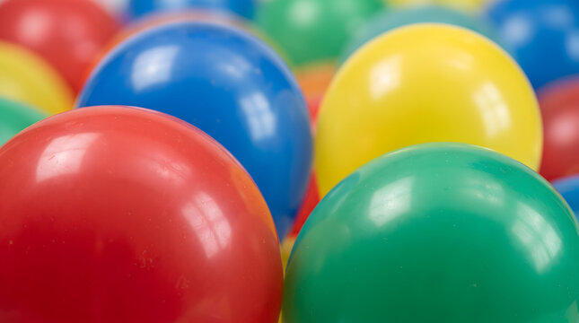 Colorful plastic play balls in a pool with bright primary colors and glossy latex texture