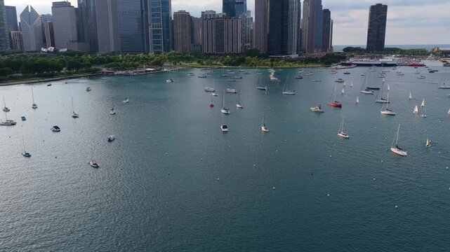 Numerous sailboats dotting Monroe Harbor on Lake Michigan with famous Chicago skyline providing urban backdrop, iconic city skyscrapers and high rises