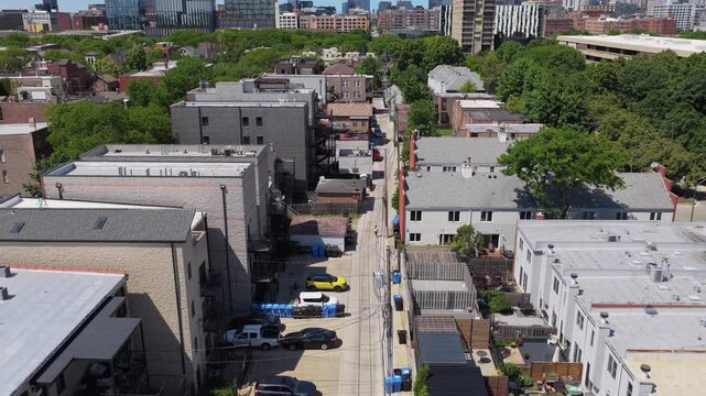 Aerial survey over Chicago urban alleyway showcasing typical residential architecture, city living infrastructure, and neighborhood community organization in bright daylight