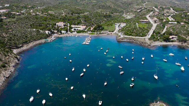 Aerial view of the peaceful Port Lligat Bay, home to Salvador Dal&iacute;'s House Museum, surrounded by crystal-clear Mediterranean waters, rocky shores and the unique landscapes of the Costa Brava. 