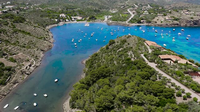 Aerial view of the peaceful Port Lligat Bay, home to Salvador Dal&iacute;'s House Museum, surrounded by crystal-clear Mediterranean waters, rocky shores and the unique landscapes of the Costa Brava. 