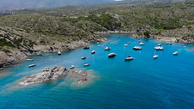Aerial view of the peaceful Port Lligat Bay, home to Salvador Dal&iacute;'s House Museum, surrounded by crystal-clear Mediterranean waters, rocky shores and the unique landscapes of the Costa Brava. 