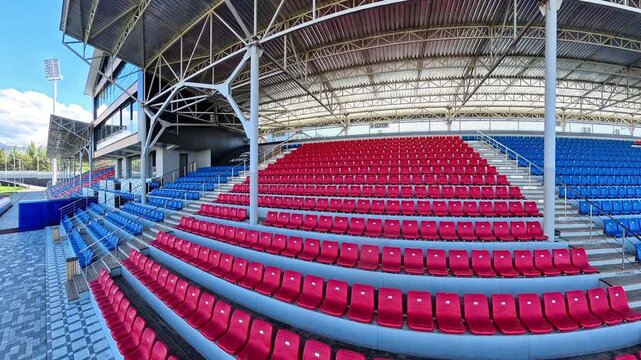 Empty sports stadium seating under roof filmed with cinematic 4K camera movement.
