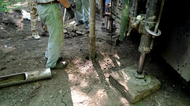 Engineers and drilling specialists operate the drilling equipment while collecting subsurface soil samples for geotechnical analysis, foundation design, and pre-construction site assessment in Ukraine