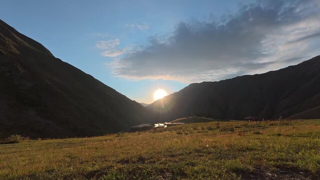 4K timelapse video of the beautiful sunset over a remote mountain village valley with clouds moving in the sky.
