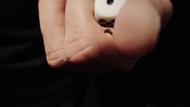 Hand holding two white gaming dice ready to roll