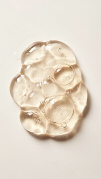 Single drop of clear cosmetic gel on a clean white surface with cosmetic skincare transparent moisturizer abstract hyaluronic treatment chemistry laboratory cosmetology substance droplets