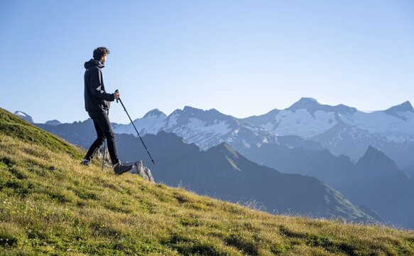 Hiker enjoying the mountain panorama in the morning, Venediger group, behind Dreiherrenkopf, Simonysitze and Gro&szlig;er Geiger, Hohen Tauern, Austria