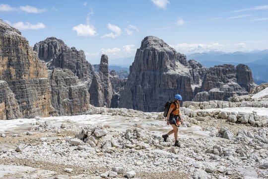 Hikers on the Sentiero Brentari hiking trail in front of cliffs, Brenta Mountains, Brenta-Adamello Natural Park, Trentino, Italy