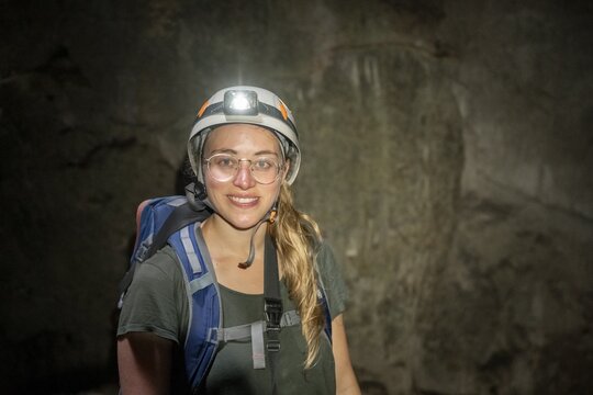 Young woman with helmet and headlamp in a stalactite cave, Terciopelo Cave, Barra Honda National Park, Costa Rica