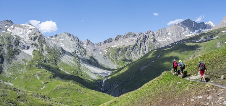 Three mountaineers on a hiking trail on the Daberlenke, view of rocky mountain peaks in the Karbachtal valley with Tredebergspitze, Las&ouml;rling H&ouml;henweg, Las&ouml;rlinggruppe, Hohe Tauern National Park, East Tyrol, Tyrol, Austria