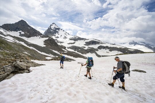 Three mountaineers crossing a snowfield, ascent to the N&ouml;rdliche M&ouml;rchnerscharte, behind summit Kleiner M&ouml;rchner, Berliner H&ouml;henweg, Zillertal Alps, Tyrol, Austria