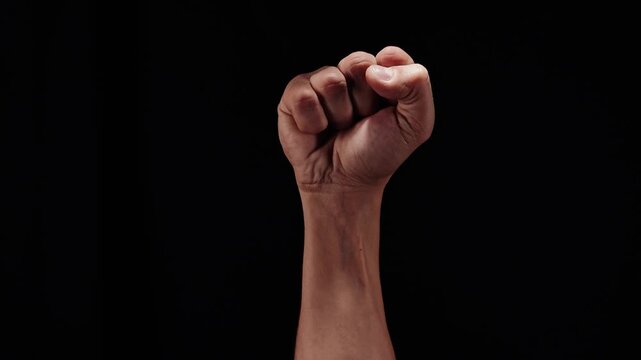 Strong man raising his clenched fist up in a gesture of victory