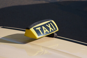 Taxi roof sign mounted on passenger car driving through an urban street © Aleksandr Fedosov