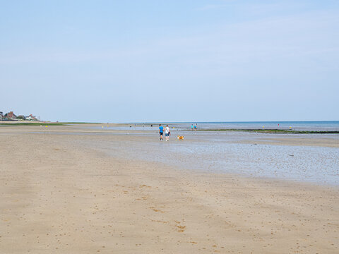 Playa de Saint-Aubin-sur-Mer, vista de la playa con mucho espacio y arena mojada sobre cielo azul, al fondo la l&iacute;nea del horizonte, viajando en verano 2022