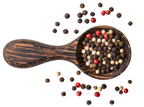 Isolated colorful peppercorns mix in a rustic wooden spoon with scattered spices, cooking ingredient