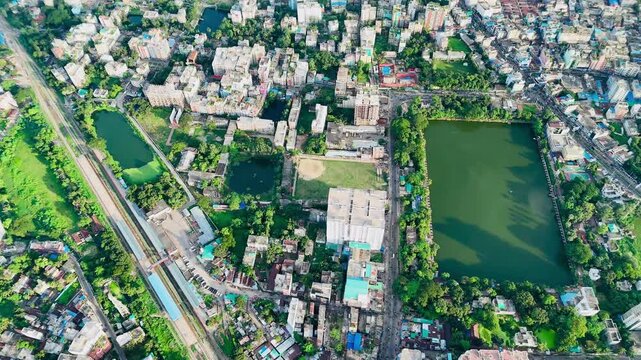 Aerial drone view of urban cityscape with green ponds and residential neighborhoods