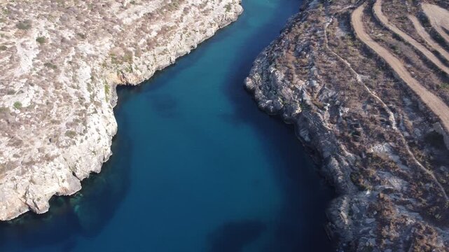 Ix-xini, Gozo, Malta - serene aerial view of rocky coastline with rugged terrain and blue water in natural landscape. High quality 4k footage