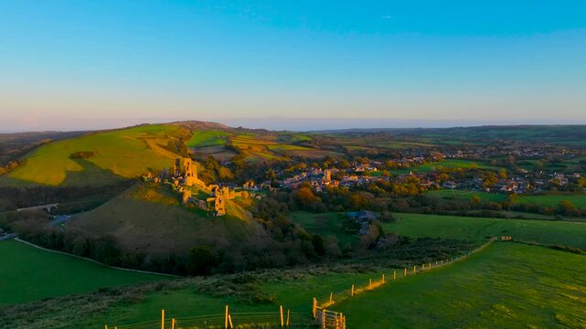 Aerial sunset view of Corfe Castle, a village and civil parish in the English county of Dorset, UK