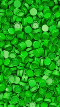 Pan across a pile of green plastic bottle caps for recycling and plastic industry production, 3D render dynamic Vertical video.
