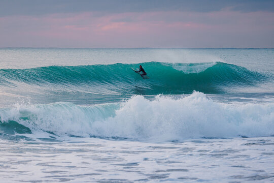 Surfer and crashing ocean wave. Surfing lifestyle and water sport concept.