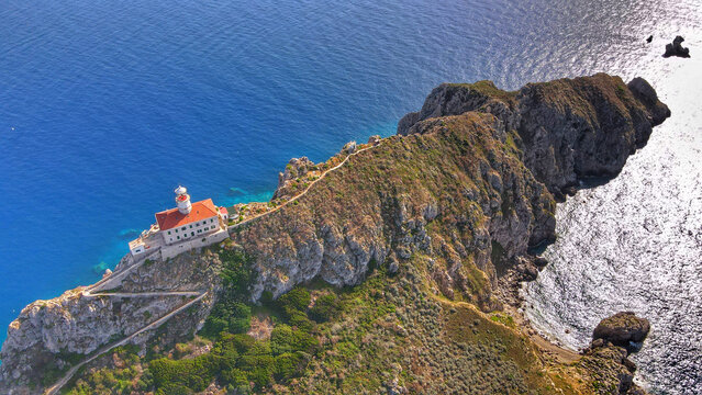 Aerial view of the historic Palagruza lighthouse perched on a rugged cliffside surrounded by the deep blue Adriatic Sea in Palagruza, Split-Dalmatia County, Croatia.